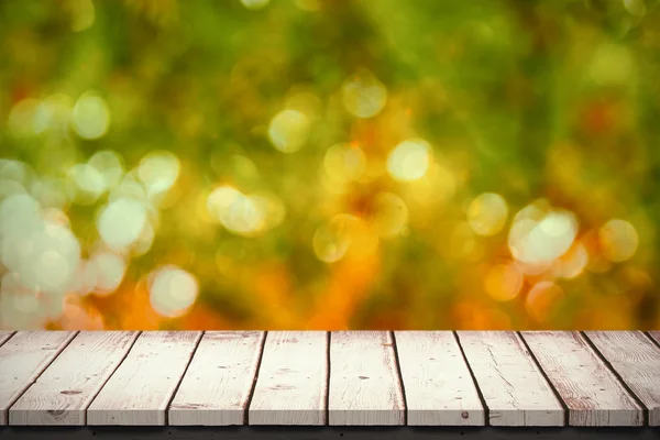 Table en bois contre les feuilles déconcentrées — Photo