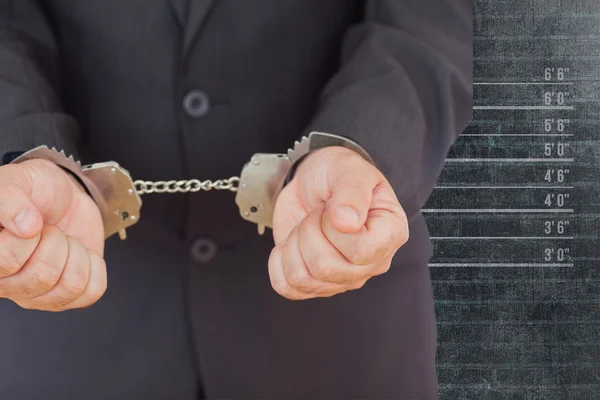 Handcuffed businessman against black wall — Stock Photo, Image