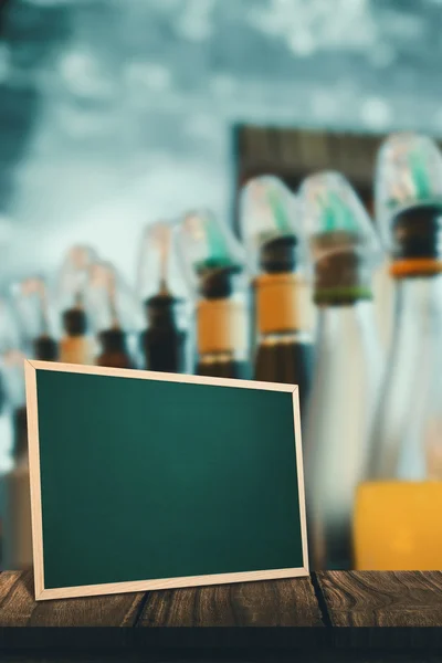 Alcohol bottles against chalkboard — Stock Photo, Image