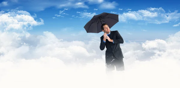 Geschäftsmann steht unter schwarzem Regenschirm — Stockfoto
