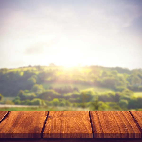 Wooden table against country scene — Stock Photo, Image