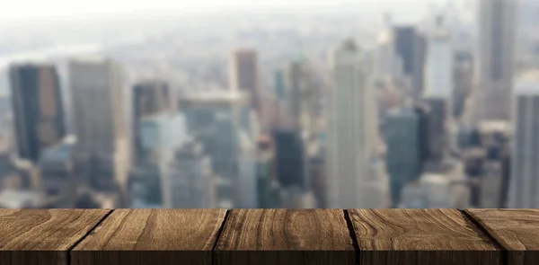 Wooden desk against view of cityscape — Stock Photo, Image