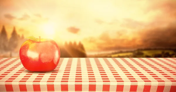 Red apple against country scene — Stock Photo, Image