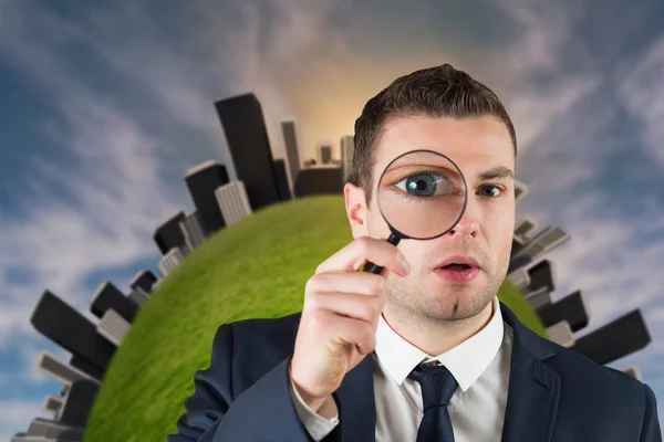 Businessman looking through magnifying glass — Stock Photo, Image