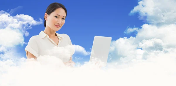 Composite image of asian businesswoman using laptop — Stock Photo, Image