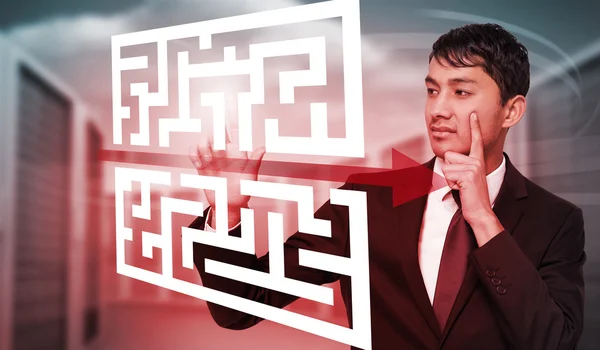 Thoughtful businessman touching maze — Stock Photo, Image