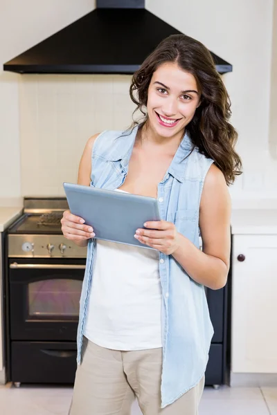 Νεαρή γυναίκα χρησιμοποιώντας ψηφιακή δισκίο στην κουζίνα — Φωτογραφία Αρχείου