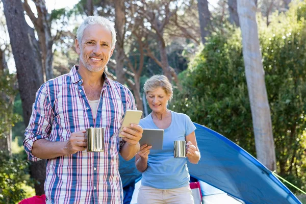 Senior couple standing beside their tent — Stock Photo, Image