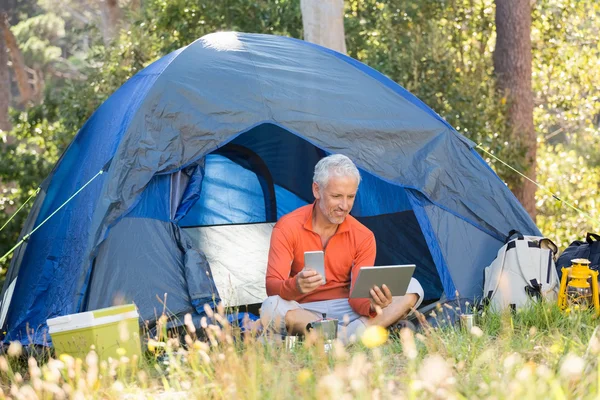 Mature man using tablet and phone — Stock Photo, Image