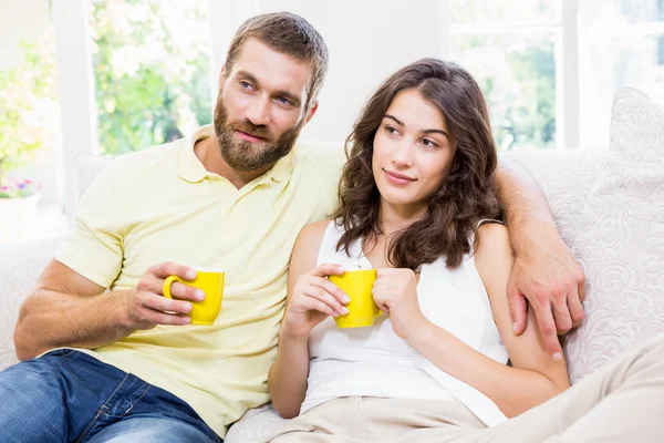 Couple having a coffee in living room — Stock Photo, Image