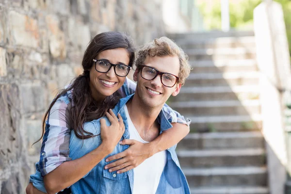 Ung man ger piggyback till sin kvinna — Stockfoto