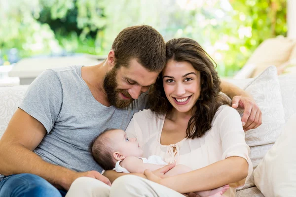 Pais felizes com seu bebê na sala de estar — Fotografia de Stock