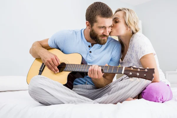 女性がキスしながらギターを弾く男 — ストック写真