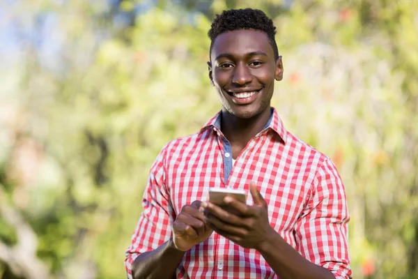 Lycklig man poserar och hålla sin smartphone — Stockfoto