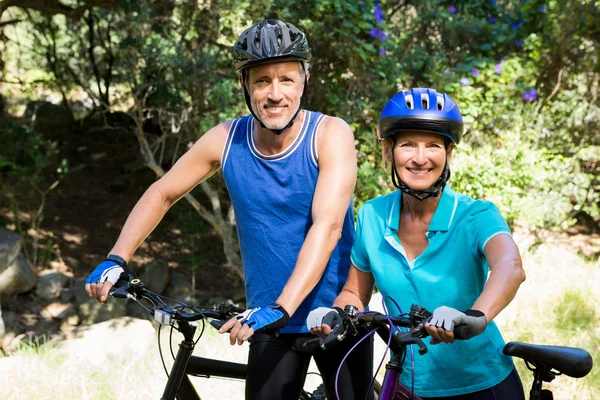 Pareja madura posando con su bicicleta — Foto de Stock