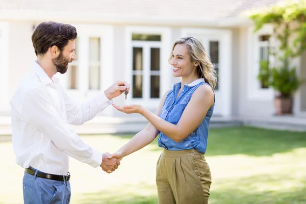 Real estate agent giving keys to woman — Stock Photo, Image