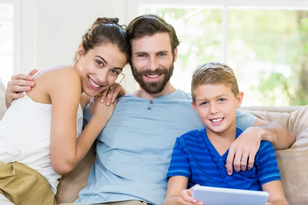 Батьки і син сидять на дивані з рукою навколо — стокове фото