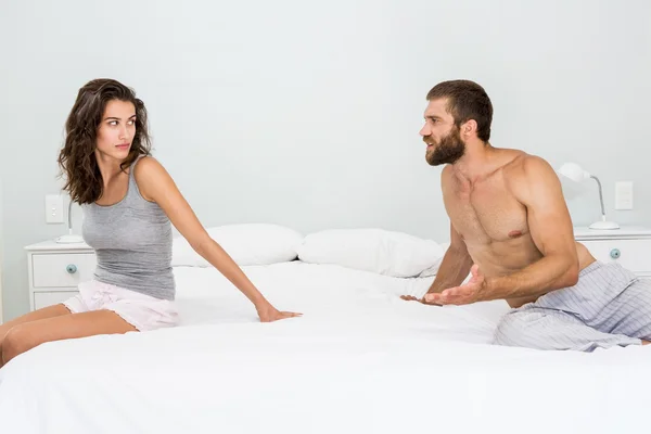 Homem discutindo com mulher na cama — Fotografia de Stock