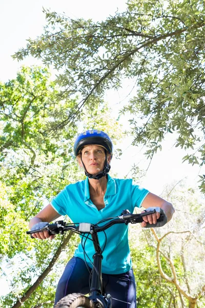 Senior mulher está em sua bicicleta — Fotografia de Stock