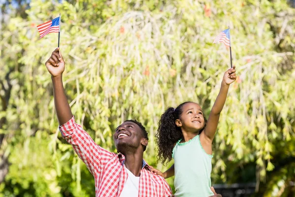 Familia feliz mostrando bandera de EE.UU. — Foto de Stock