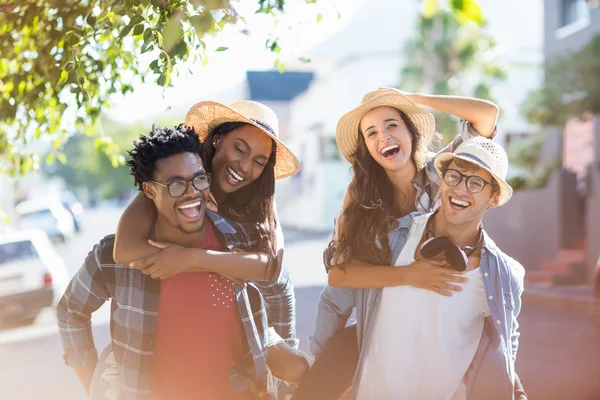 Giovani uomini che danno a cavalluccio alle donne — Foto Stock