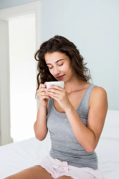 Mujer tomando café en la cama —  Fotos de Stock