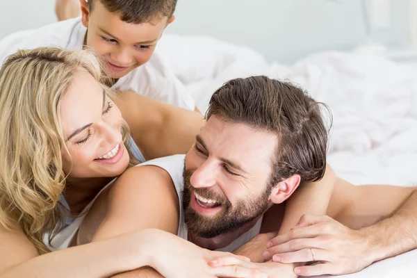 Föräldrar och son liggande på sängen och ha roligt — Stockfoto