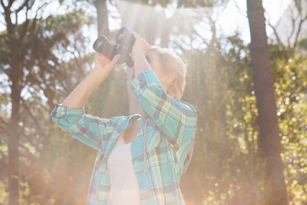 Mature woman looking on binoculars — Stock Photo, Image