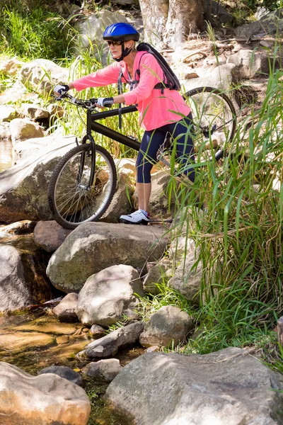 Senior vrouw loopt met haar fiets — Stockfoto