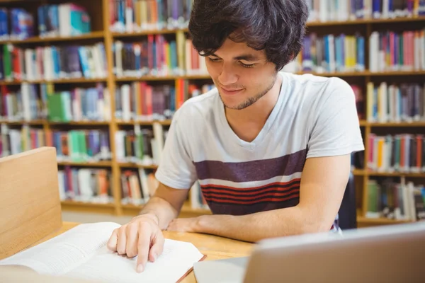 Genç öğrenci kitap okuma masada oturan — Stok fotoğraf