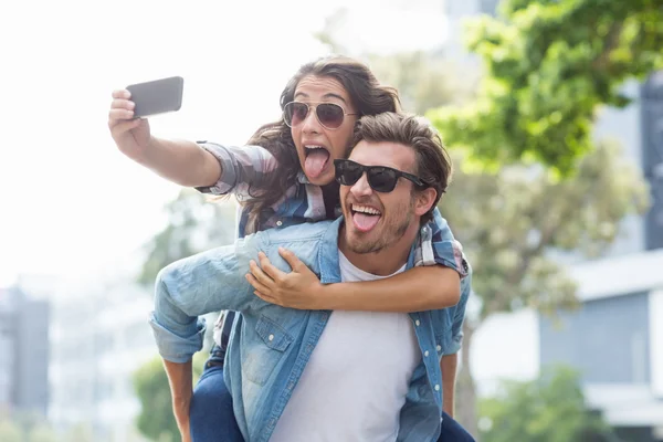 Homem dando piggyback para mulher — Fotografia de Stock