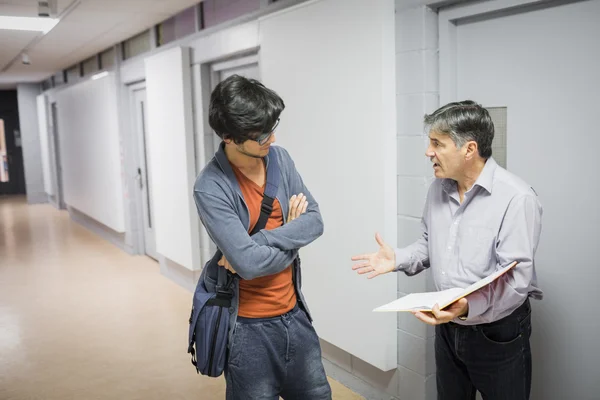 Professeur avec cahier parlant à un étudiant — Photo