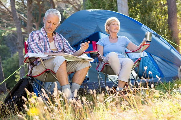 Senior couple relaxing beside their tent — Stock Photo, Image