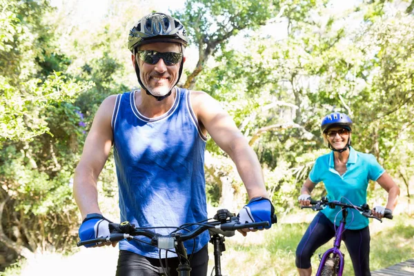 Зрелая пара в солнечных очках на велосипеде — стоковое фото