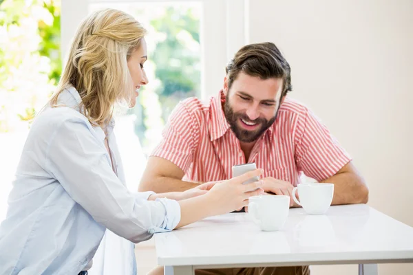 Het tonen van haar mobiele telefoon aan man vrouw — Stockfoto