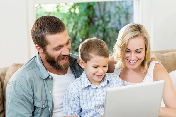 Los padres y el hijo usando ordenador portátil en la sala de estar —  Fotos de Stock
