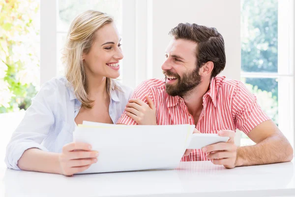 Lächelndes Paar überprüft seine Rechnungen — Stockfoto