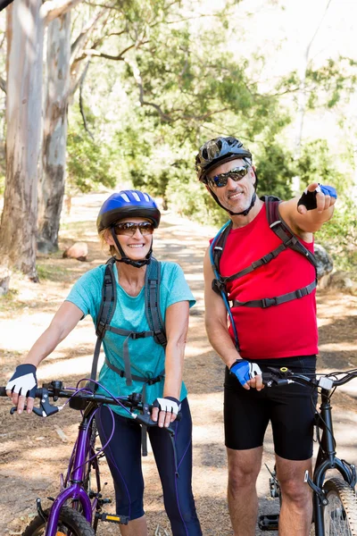 Casal sênior de pé com sua bicicleta — Fotografia de Stock