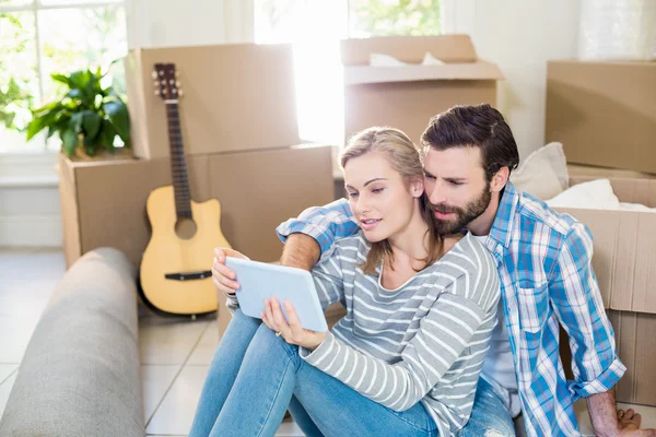 Couple sitting on floor and using digital tablet — Stock Photo, Image