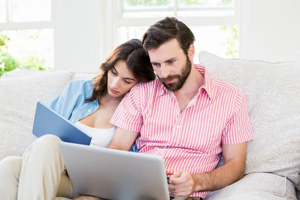 Paar nutzt digitales Tablet und Laptop im Wohnzimmer — Stockfoto