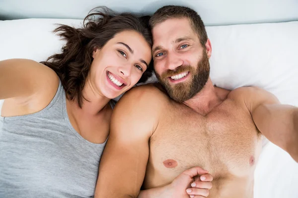 Portret para uśmiechający się na łóżku — Zdjęcie stockowe