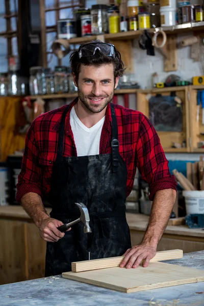 Snickare leende och arbetar på sitt hantverk — Stockfoto