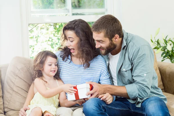 Daughter receiving surprise a gift from her parents — Stock Photo, Image