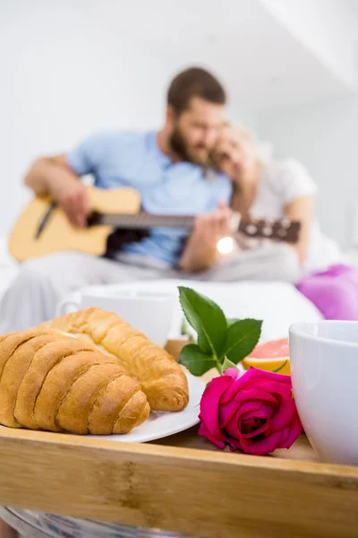 Croissant e uma rosa na bandeja — Fotografia de Stock