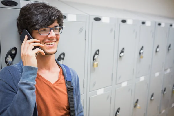 Happy student talking on phone in locker room — Stock Photo, Image