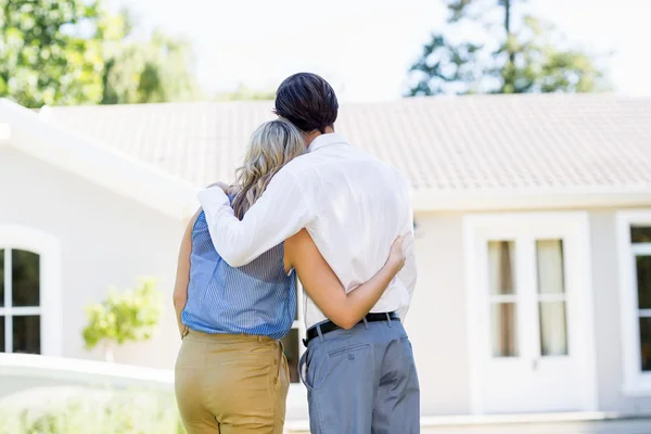 Bakifrån av par som står med armen runt — Stockfoto