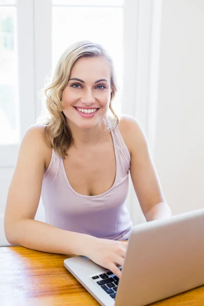 Portrait of young woman sitting at table — Stock Photo, Image