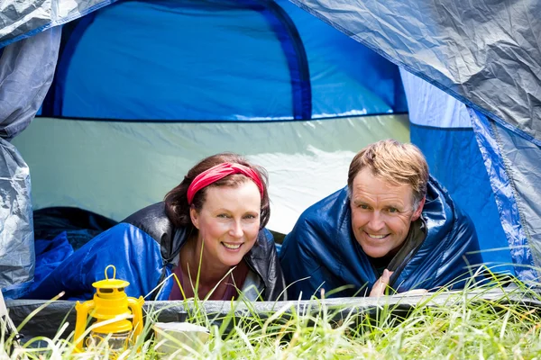 Пожилая пара улыбается в своей палатке — стоковое фото