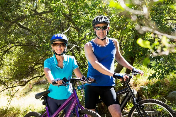 Casal sênior de pé com suas bicicletas — Fotografia de Stock