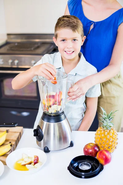 Mother assisting son to prepare juice — Stock Photo, Image